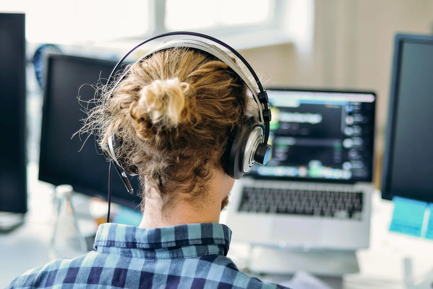 Young man doing e-learning with headphones in front of his computer