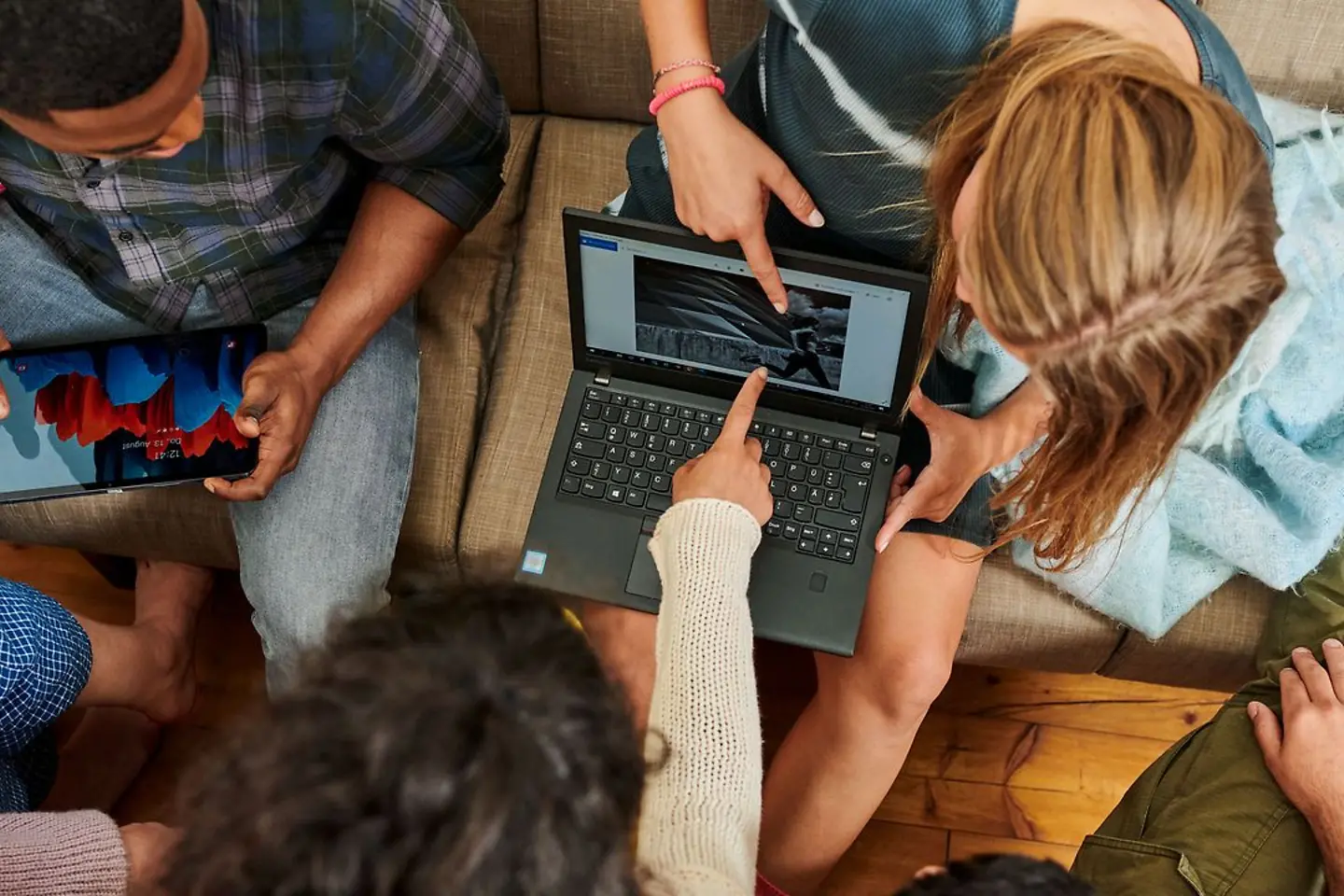 Mehrere Leute schauen auf den Bildschirm eines Laptops
