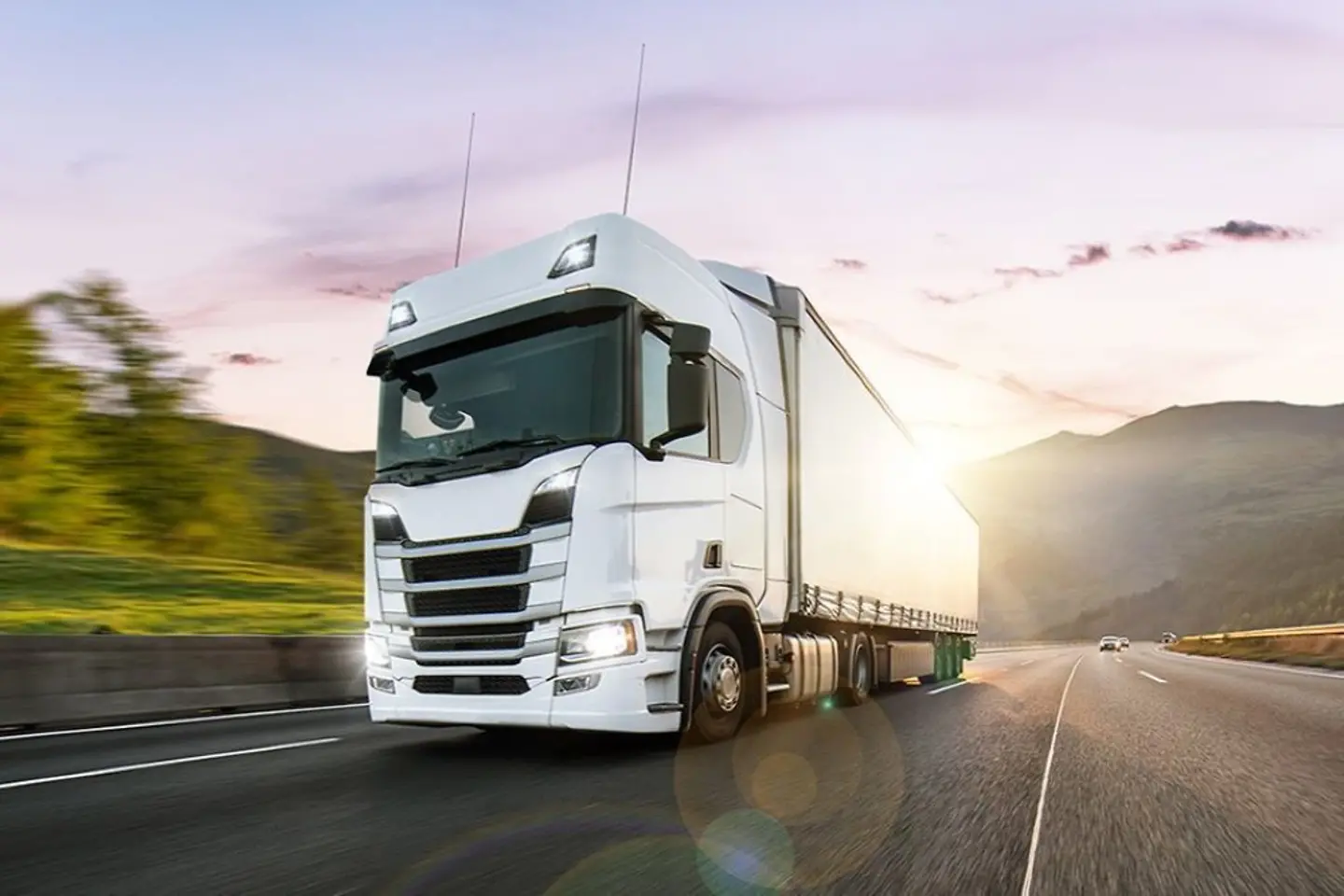 White truck driving in the sunset on a motorway 