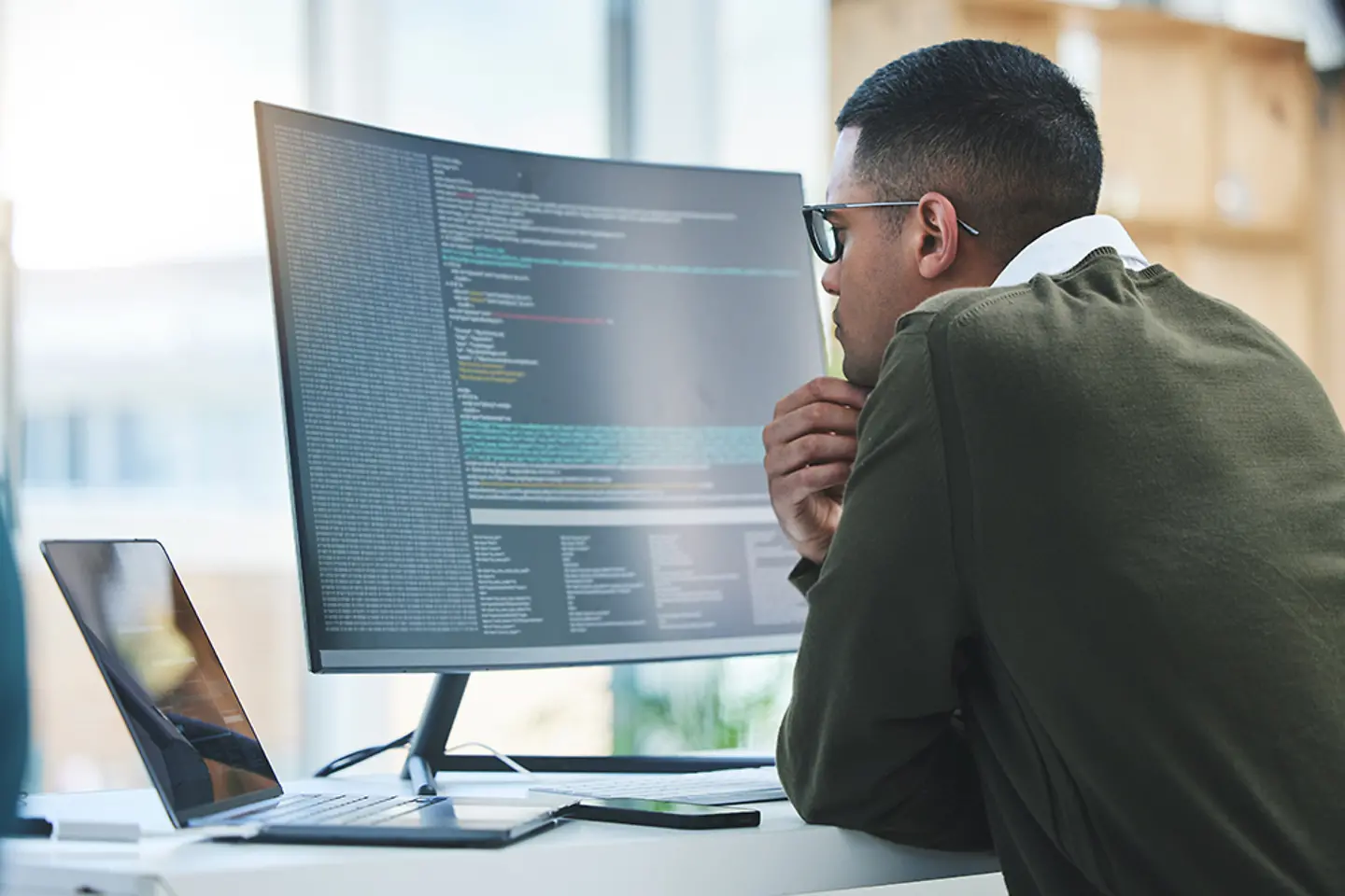 Softwareentwickler vor Computerbildschirm