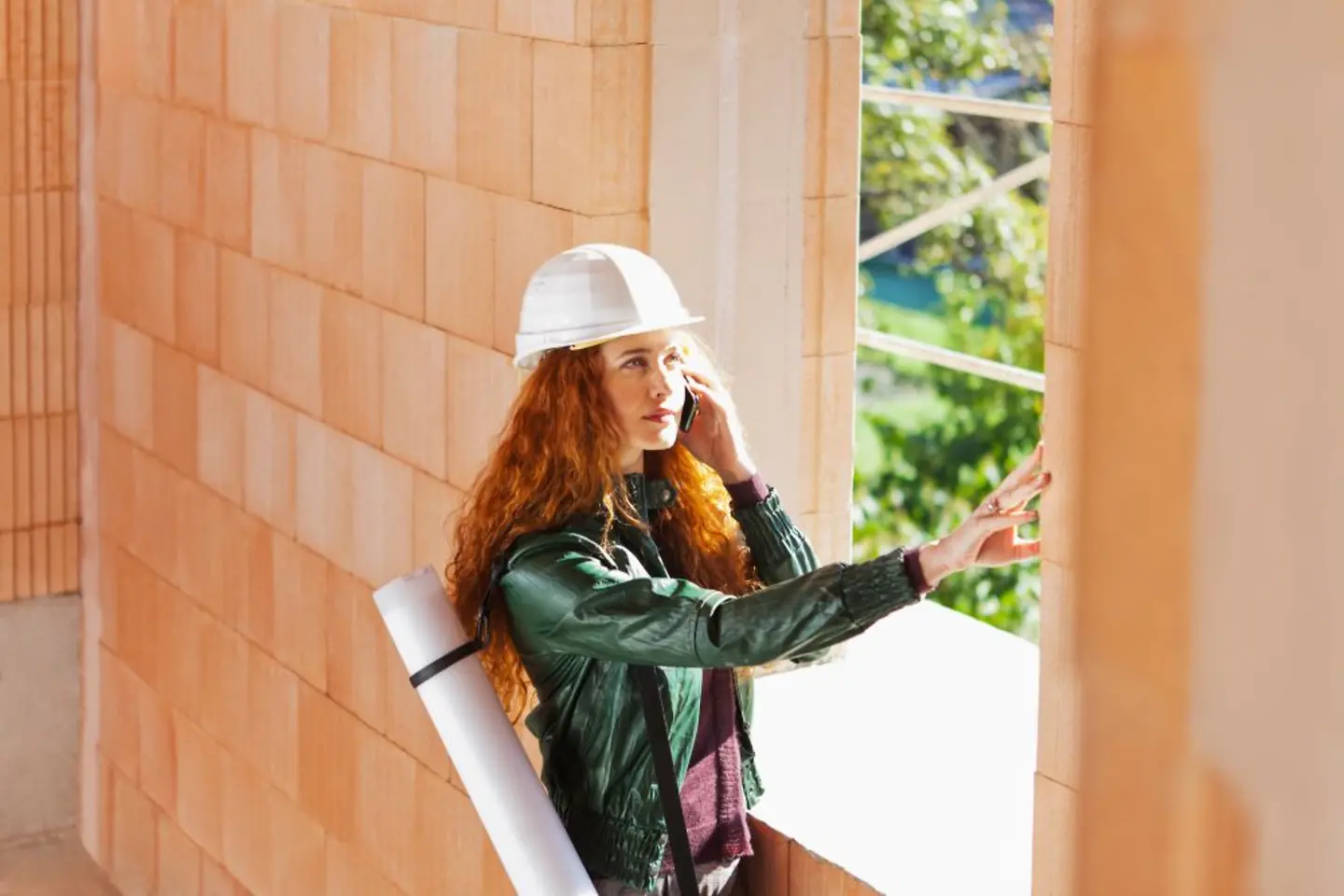 Female architect inspecting a brick wall