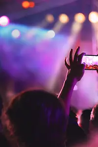 Un hombre haciendo una foto con su celular en un evento