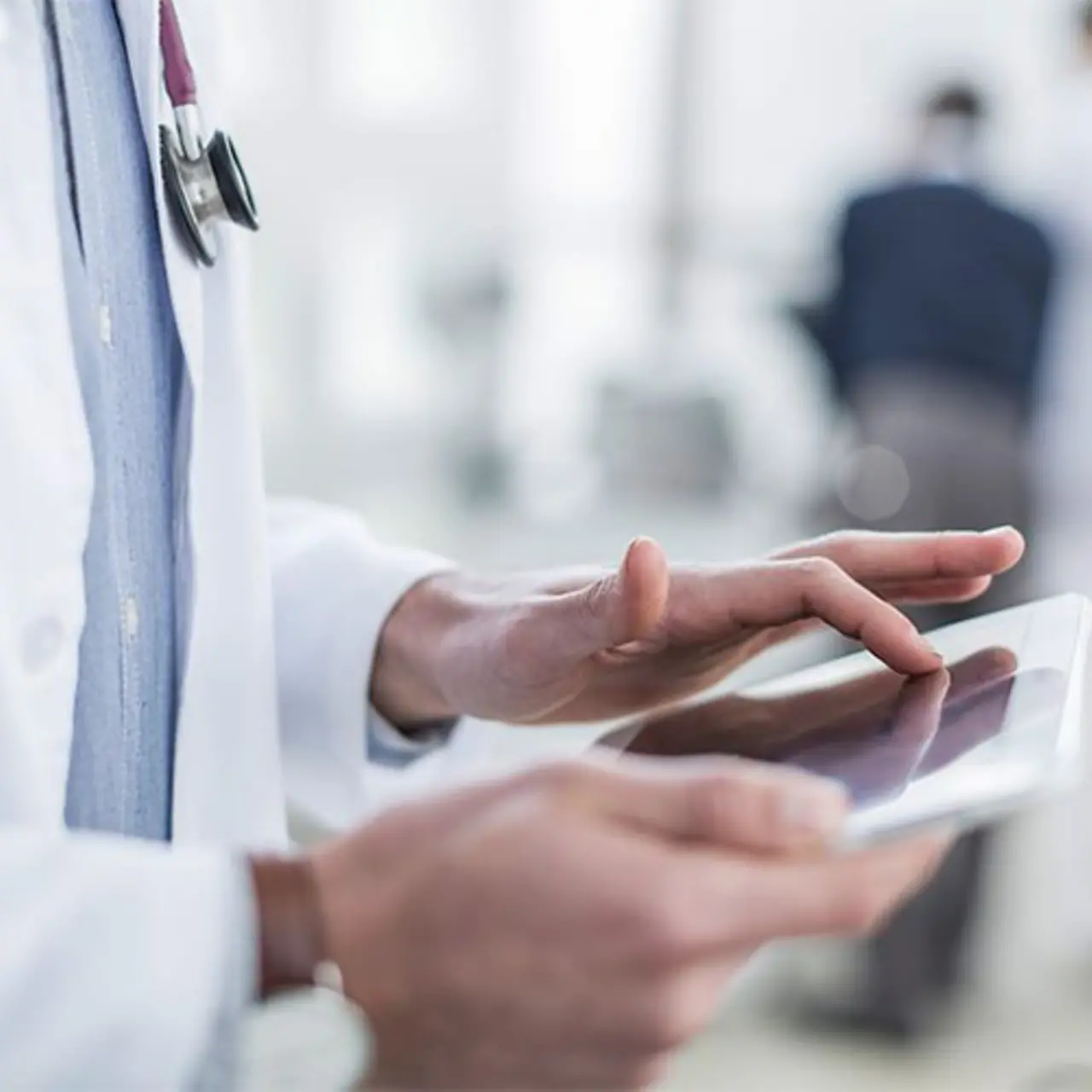 Arzt prüft Patientendaten über ein Tablet