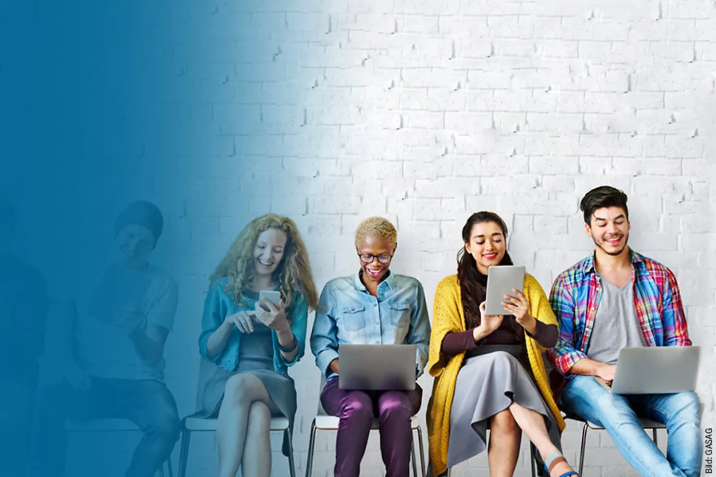 Several people sit on chairs and look at laptops and tablets.